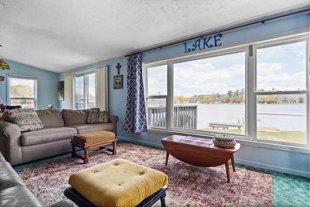 living room with a water view, carpet flooring, lofted ceiling, and a textured ceiling