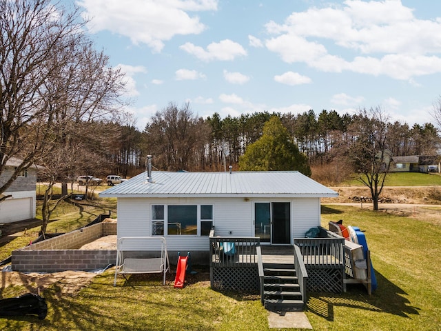 back of house with fence, a deck, metal roof, and a lawn