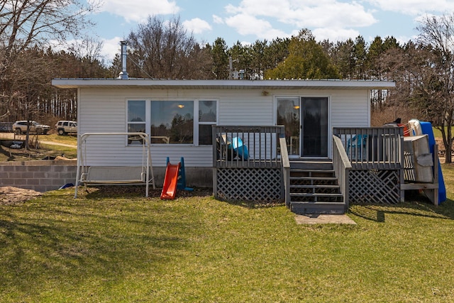 rear view of house featuring a deck and a lawn