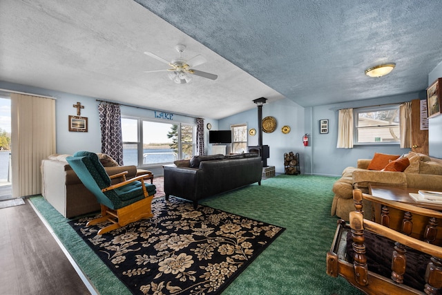 carpeted living area with plenty of natural light, a textured ceiling, and ceiling fan