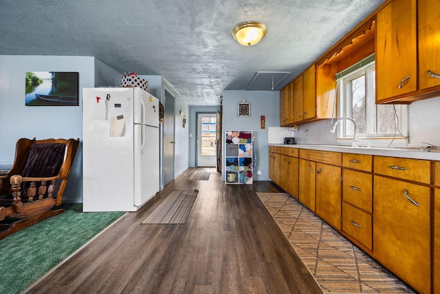 kitchen with light countertops, freestanding refrigerator, and dark wood finished floors