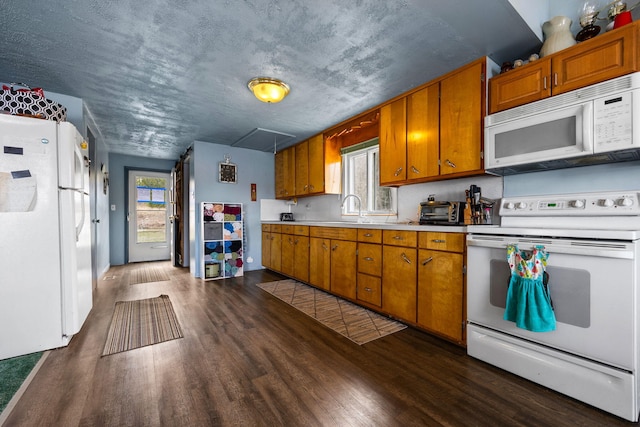kitchen featuring white appliances, a sink, light countertops, brown cabinets, and dark wood-style floors
