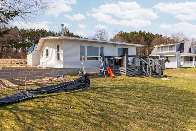 back of house featuring a deck and a lawn