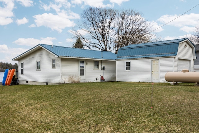 back of property featuring an outbuilding, a gambrel roof, metal roof, and a yard