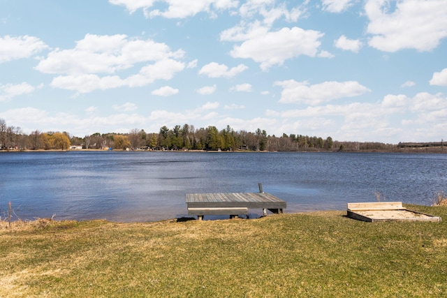 view of dock with a water view and a yard