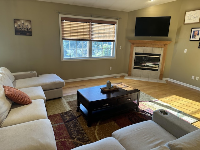 133 Bingham Dr, Brooklyn, MI 49230 - living area featuring wood finished floors, a tile fireplace, lofted ceiling, and baseboards