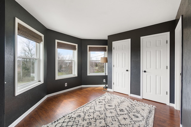 14204 Northmoor Dr, Cement City, MI 49233 - unfurnished bedroom featuring multiple windows, baseboards, and wood finished floors