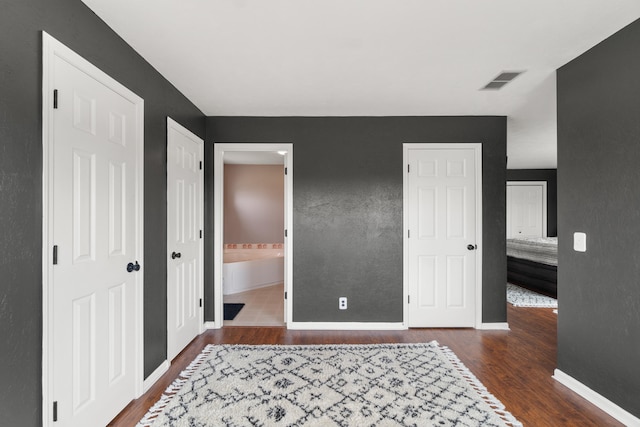 14204 Northmoor Dr, Cement City, MI 49233 - bedroom featuring wood finished floors, ensuite bathroom, baseboards, and visible vents