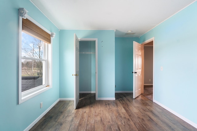 14204 Northmoor Dr, Cement City, MI 49233 - unfurnished bedroom featuring a closet, baseboards, crown molding, and wood finished floors