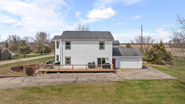 14204 Northmoor Dr, Cement City, MI 49233 - back of house featuring a yard, an attached garage, a deck, and aphalt driveway