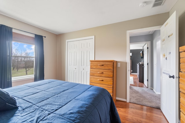 14204 Northmoor Dr, Cement City, MI 49233 - bedroom with baseboards, wood finished floors, a closet, and visible vents