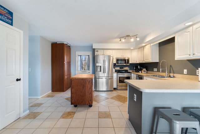 14204 Northmoor Dr, Cement City, MI 49233 - kitchen with a peninsula, light tile patterned floors, white cabinetry, appliances with stainless steel finishes, and a sink