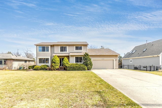3755 Oak Dr, Ypsilanti, MI 48197 - traditional-style home with an attached garage, fence, stucco siding, a front lawn, and driveway
