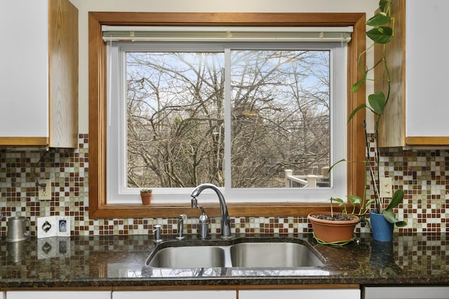 3755 Oak Dr, Ypsilanti, MI 48197 - kitchen featuring dark stone countertops, a sink, and decorative backsplash