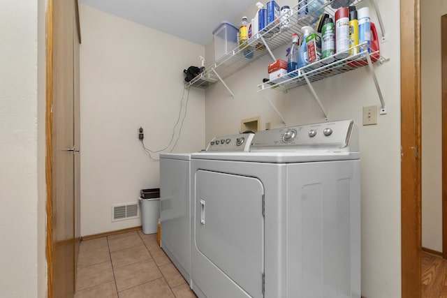 3755 Oak Dr, Ypsilanti, MI 48197 - laundry area with baseboards, light tile patterned flooring, visible vents, independent washer and dryer, and laundry area