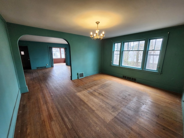 309 N Main St, Scottville, MI 49454 - spare room with arched walkways, visible vents, and wood finished floors
