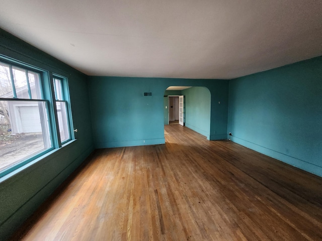 309 N Main St, Scottville, MI 49454 - spare room with visible vents, baseboards, arched walkways, and wood finished floors