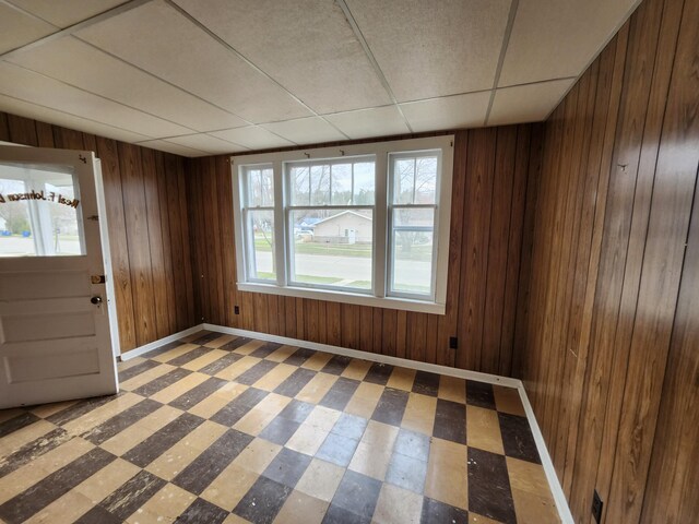 309 N Main St, Scottville, MI 49454 - interior space with tile patterned floors, wooden walls, baseboards, and a drop ceiling