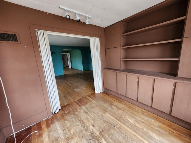 309 N Main St, Scottville, MI 49454 - interior space with arched walkways, visible vents, light wood-style flooring, and track lighting