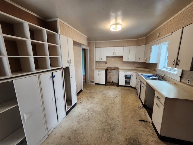 309 N Main St, Scottville, MI 49454 - kitchen featuring light countertops, white cabinetry, a sink, and backsplash