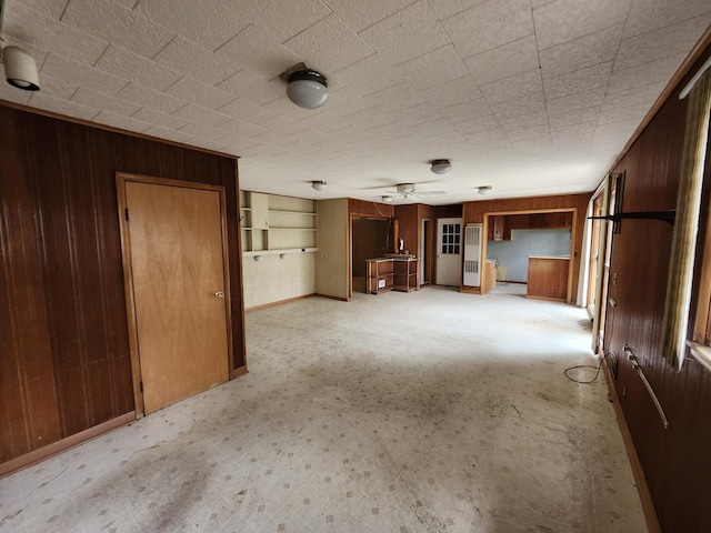 309 N Main St, Scottville, MI 49454 - unfurnished living room featuring wood walls, built in features, and a ceiling fan