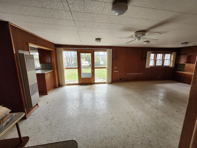 309 N Main St, Scottville, MI 49454 - unfurnished living room featuring wood walls and a ceiling fan
