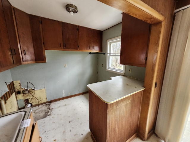 309 N Main St, Scottville, MI 49454 - interior space featuring a sink, brown cabinetry, light countertops, and light floors