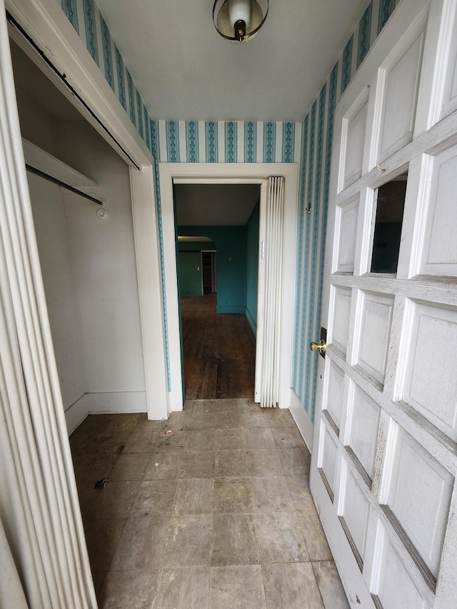 309 N Main St, Scottville, MI 49454 - corridor with french doors, wallpapered walls, baseboards, and stone finish flooring