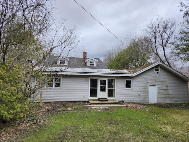 309 N Main St, Scottville, MI 49454 - rear view of house with entry steps, a lawn, and a chimney