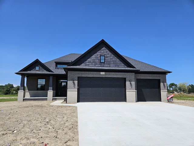 view of front of home with roof with shingles, brick siding, driveway, and an attached garage