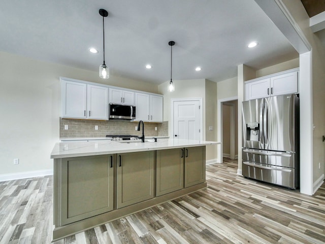 kitchen featuring white cabinets, appliances with stainless steel finishes, and baseboards