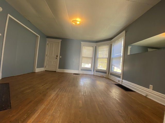interior space with hardwood / wood-style floors, baseboards, and visible vents