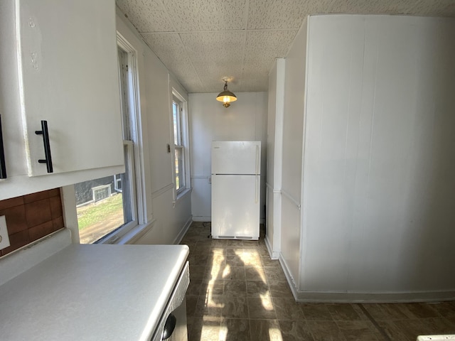 hall with a paneled ceiling and baseboards