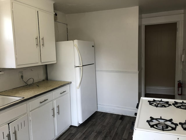 kitchen featuring white appliances, dark wood-style flooring, white cabinetry, and a sink