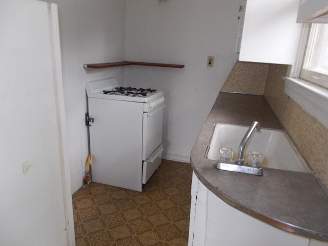 interior space with tile patterned floors, dark countertops, and white gas range oven