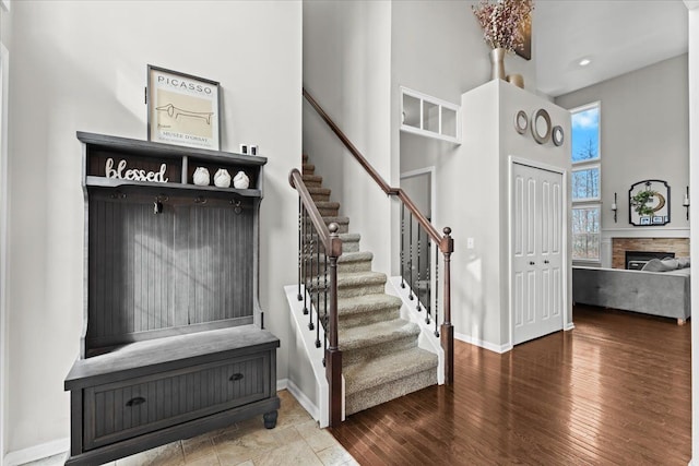 mudroom with baseboards, wood finished floors, and a fireplace