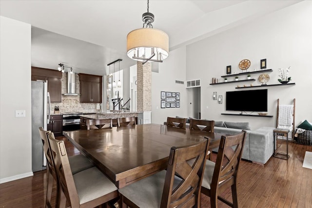 dining area with dark wood finished floors, baseboards, and visible vents