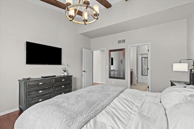 bedroom with visible vents, a chandelier, baseboards, beam ceiling, and wood finished floors