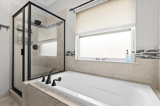 bathroom with a stall shower, tile patterned flooring, and a bath