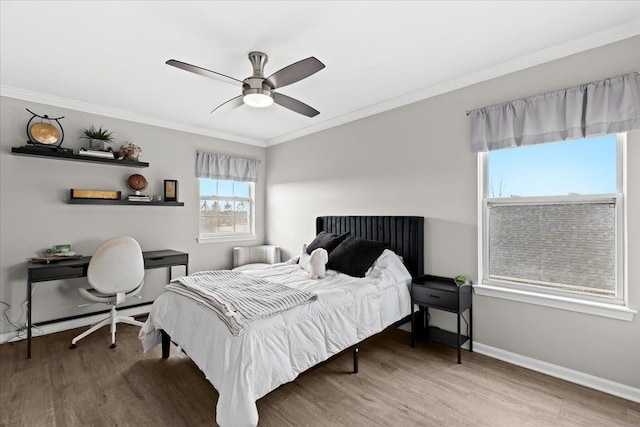 bedroom with wood finished floors, a ceiling fan, ornamental molding, and baseboards