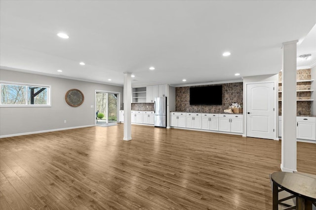 unfurnished living room with dark wood-style floors, ornate columns, and recessed lighting