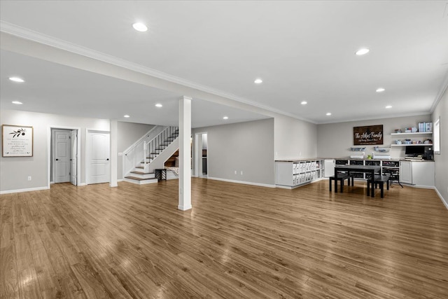 unfurnished living room featuring wood finished floors, crown molding, stairs, and baseboards
