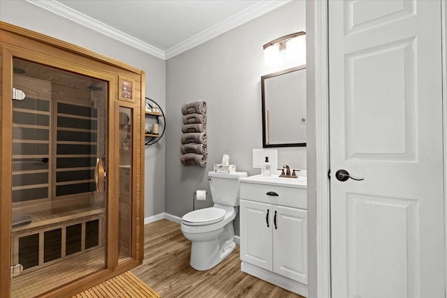 bathroom with baseboards, toilet, ornamental molding, wood finished floors, and vanity