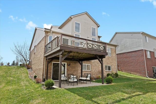 rear view of property with a patio area, an outdoor living space, a lawn, brick siding, and a deck