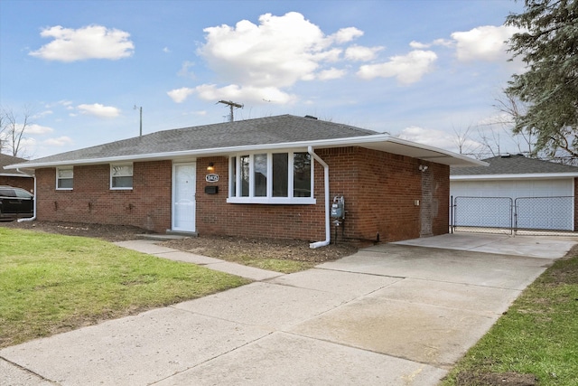 single story home featuring brick siding, a garage, an outbuilding, a front lawn, and roof with shingles
