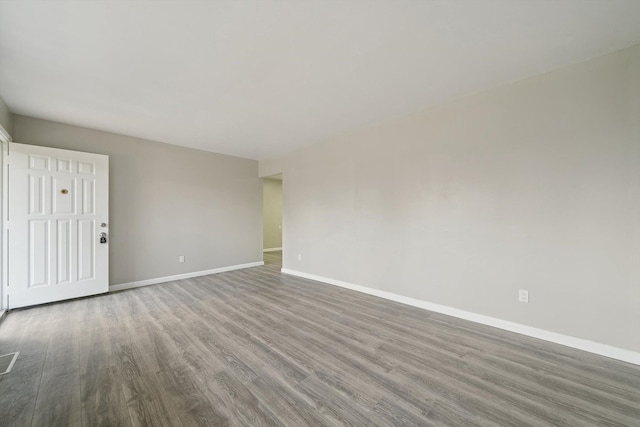 unfurnished room with baseboards and wood finished floors