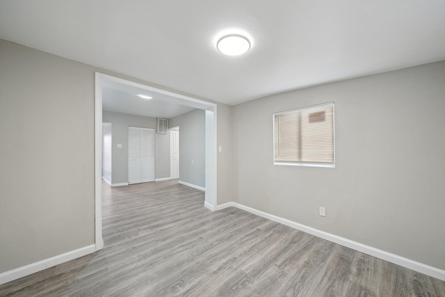spare room featuring wood finished floors and baseboards