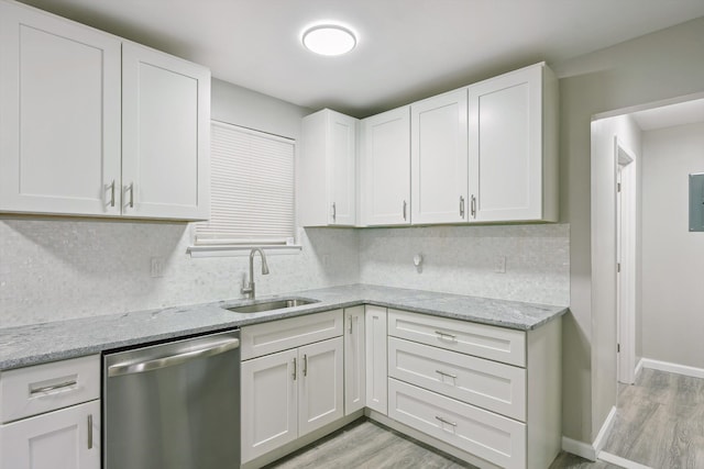 kitchen featuring a sink, stainless steel dishwasher, decorative backsplash, and light wood-style floors