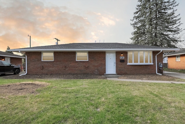 view of front of house with a front yard and brick siding