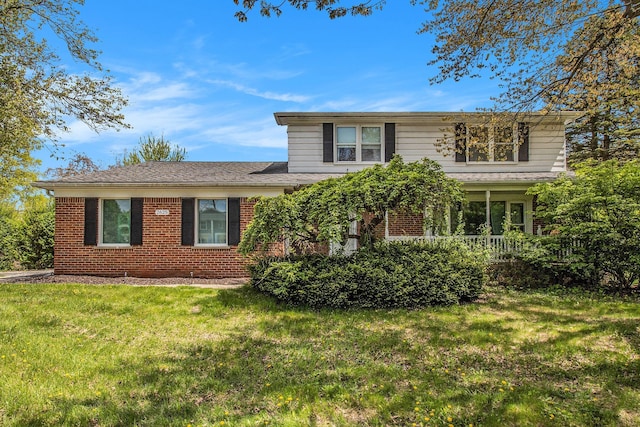 traditional-style home with brick siding and a front lawn